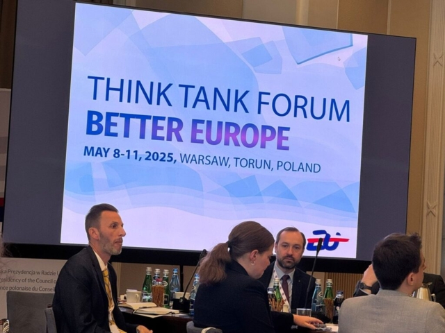 Uczestnicy Forum siedzą przy stole  podczas debaty