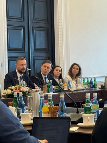 Uczestnicy Forum siedzą przy stole  podczas debaty